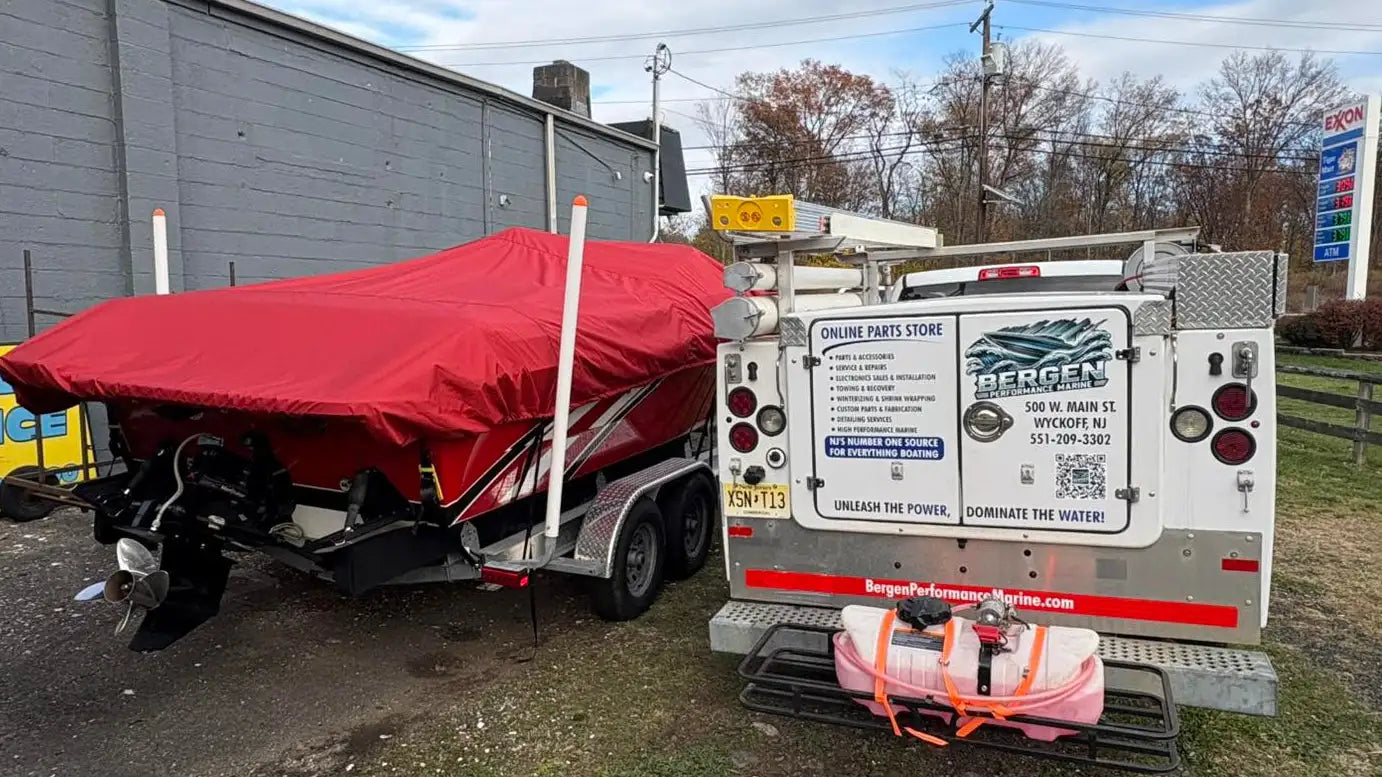Red boat cover draped over a motorboat on a trailer.