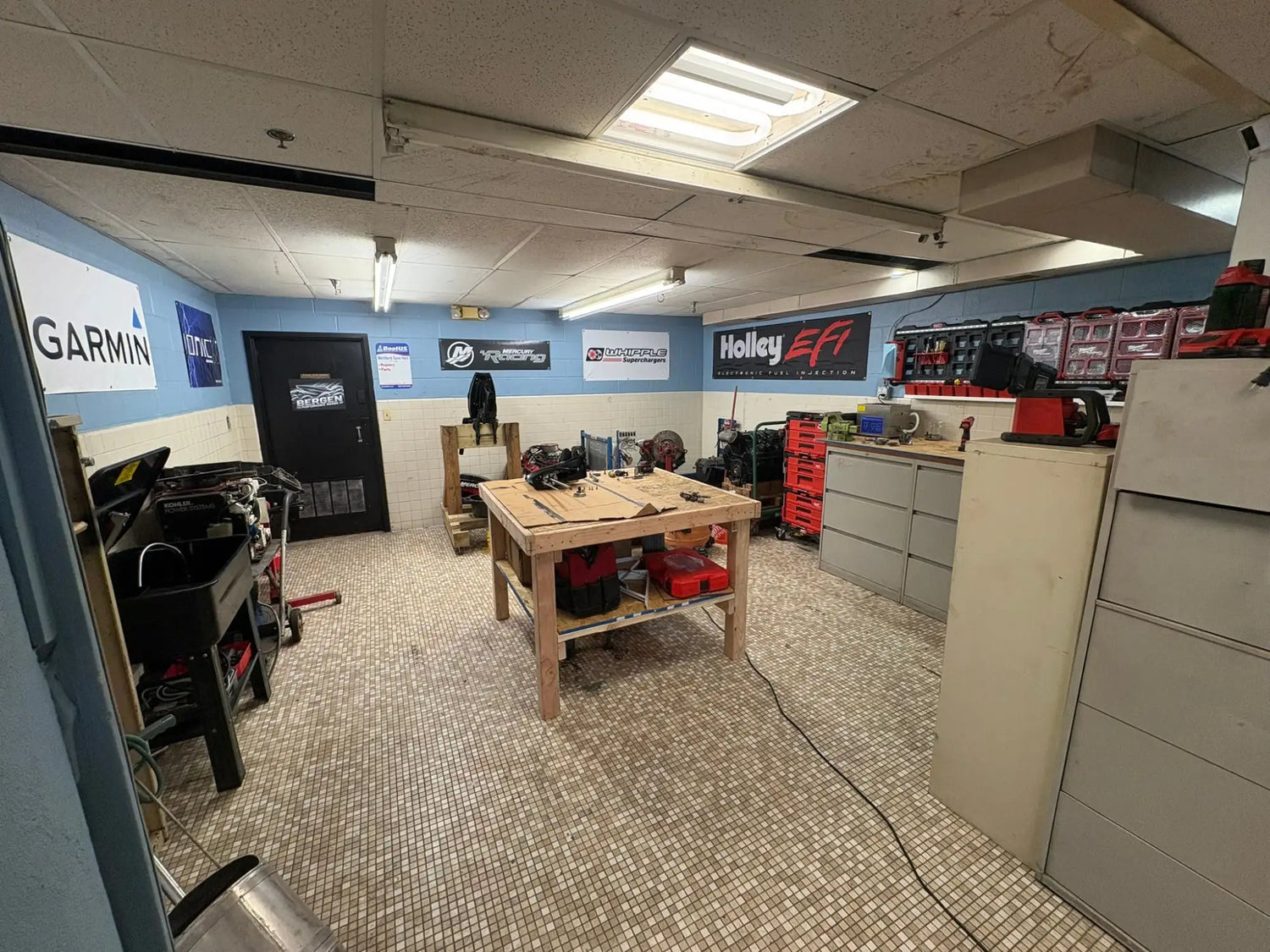 Wooden workbench with red toolboxes and black machinery on top